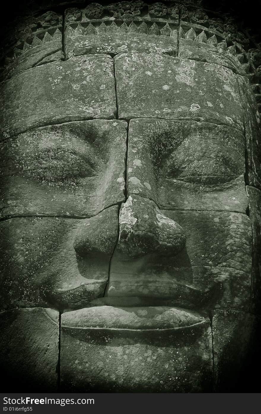 Photo of the face of Buddha/Buddah meditating. Bayon temple (devoted to Buddhism), Angkor temple complex, Cambodia. Vertical composition.