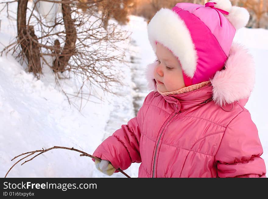 Pretty little girl drawing on the snow.