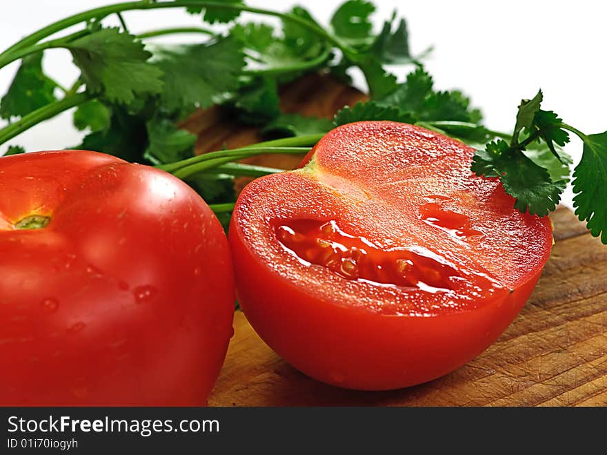 Tomato and coriander on wooden plate