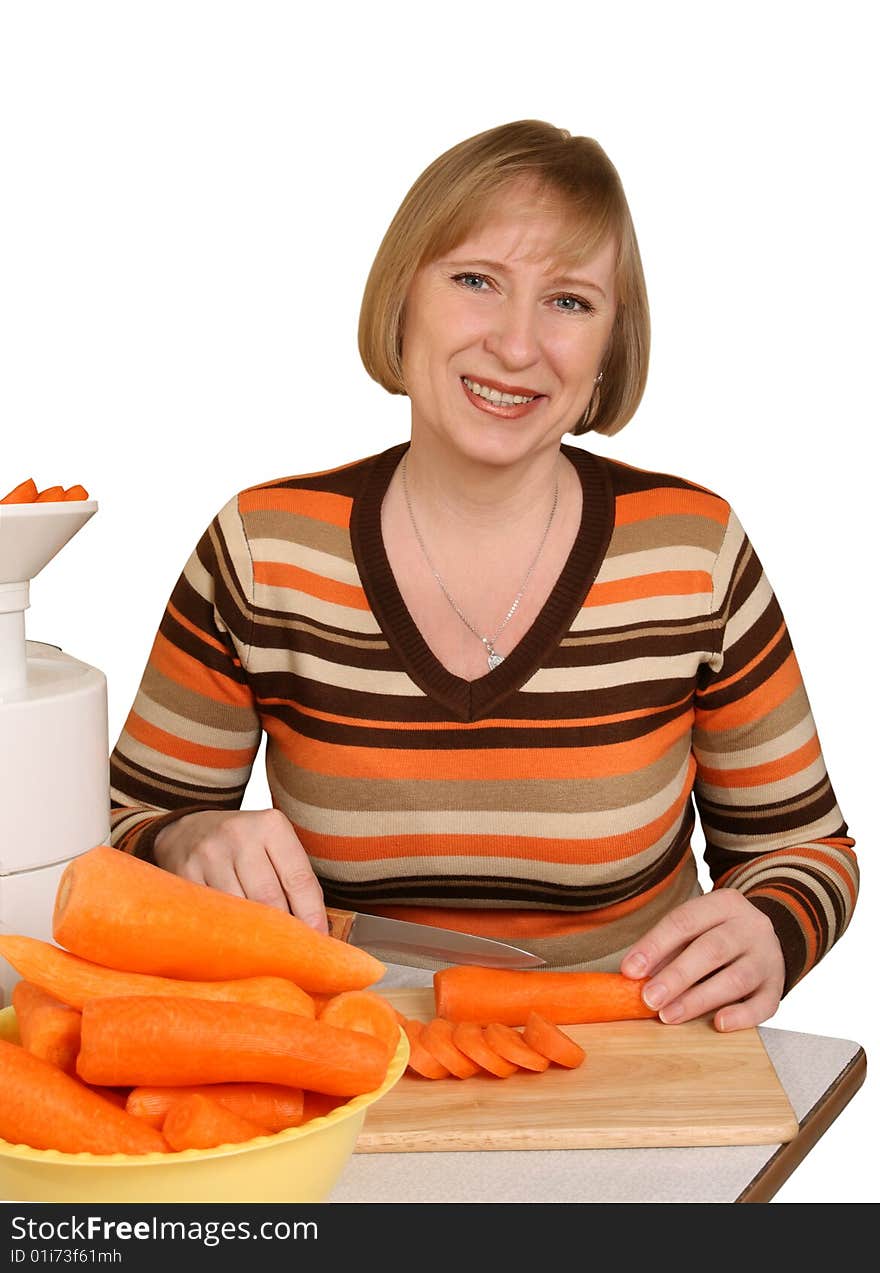 The woman slices carrots for preparation of juice. The woman slices carrots for preparation of juice