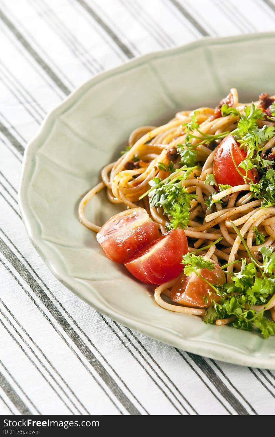 Spaghetti with tomato sauce and herbs served on rustic plate