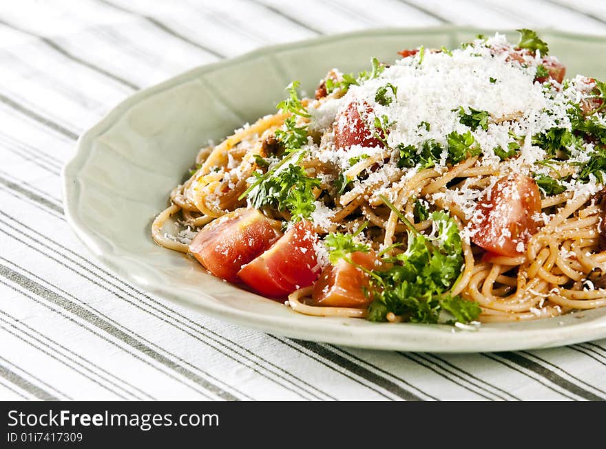 Spaghetti with tomato sauce and herbs served on rustic plate