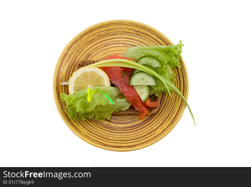 A sandwich with smoked fish; salad; onion; lemon and fresh cucumber isolated on white. A sandwich with smoked fish; salad; onion; lemon and fresh cucumber isolated on white