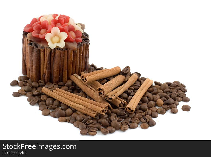 A decorative candle, pile of coffee beans and several cinnamon sticks isolated on white. A decorative candle, pile of coffee beans and several cinnamon sticks isolated on white