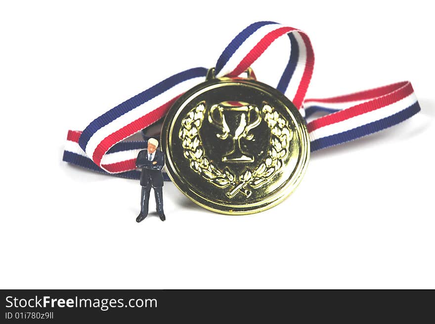 A man standing next to a gold medal. A man standing next to a gold medal