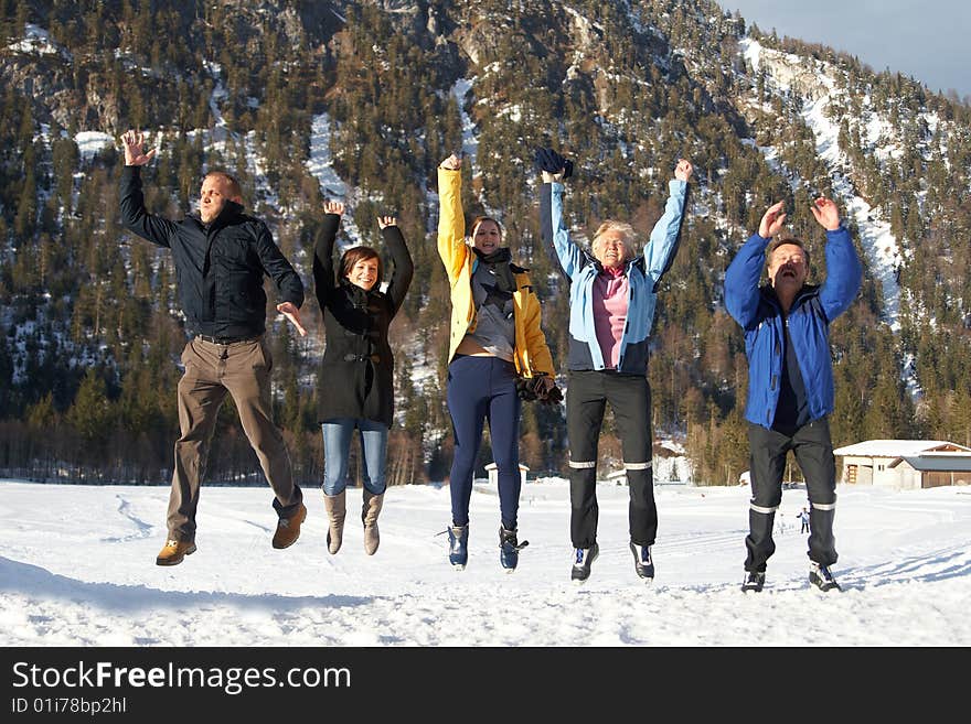 Family in a and outdoor winter setting. Jumping in joy! Slight motion bluriness is intended.