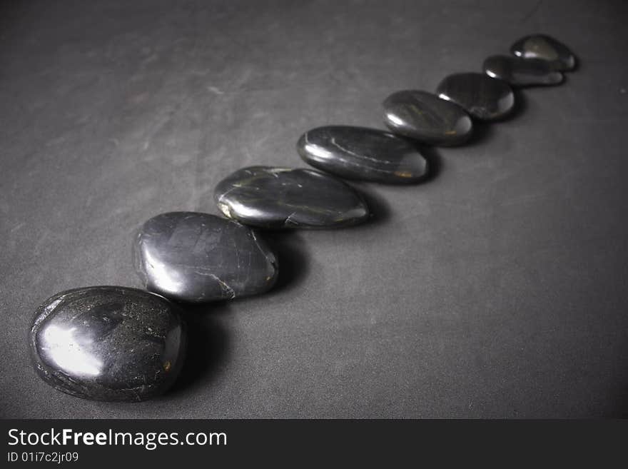 Three zen stones on a gray background.