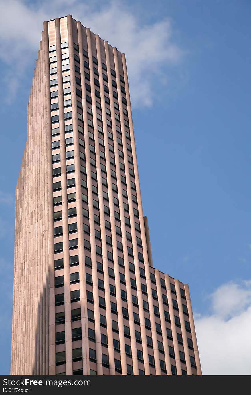 Tall Jutting Granite Building against blue sky