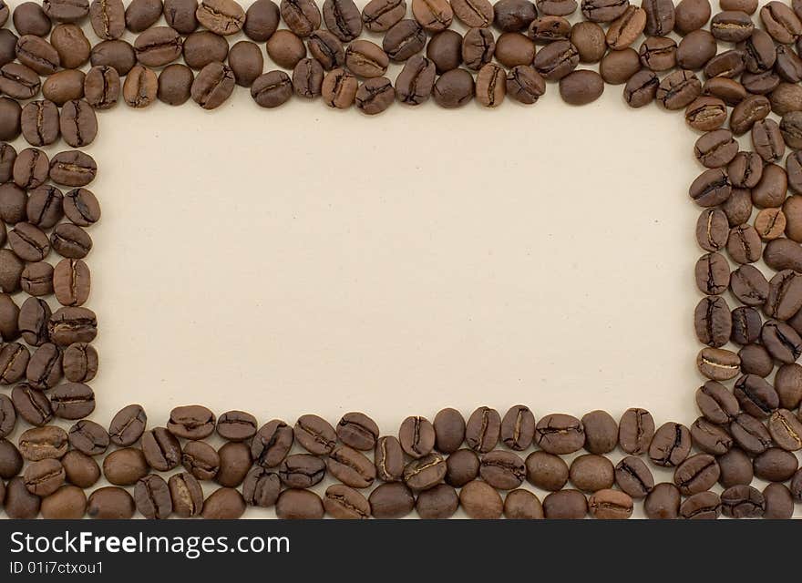 A frame made of coffee beans laid out on brown paper. A frame made of coffee beans laid out on brown paper