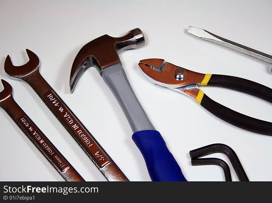 An assortment of tools isolated on white. Tools include wrenches, hammer, screwdriver and hex keys.