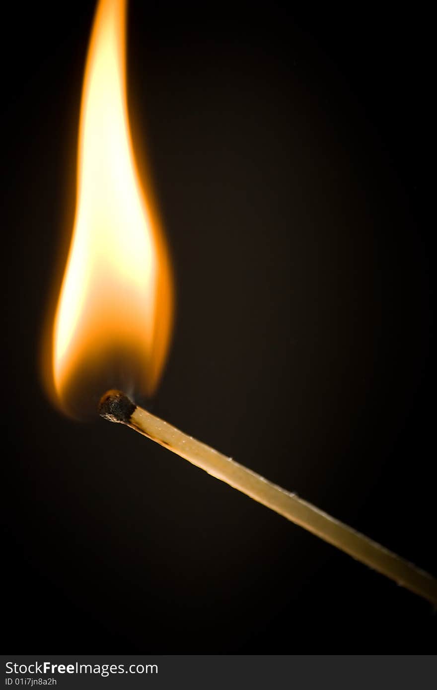 Burning match on black background