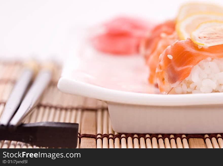 Sushi on the white plate and chopsticks