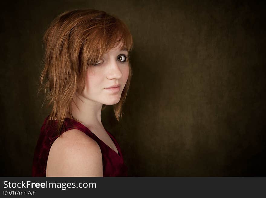 Pretty young girl with red hair on a green background. Pretty young girl with red hair on a green background