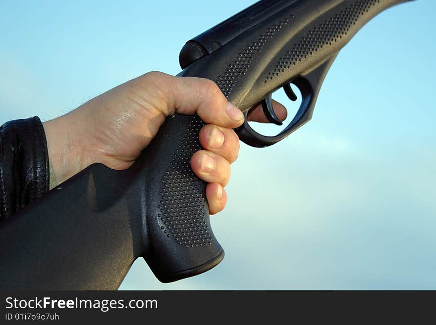 Man hand holding gun over sky calling forward closeup shot