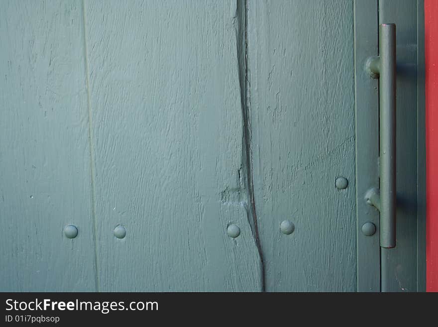 A green wooden door with an iron knob. A green wooden door with an iron knob.