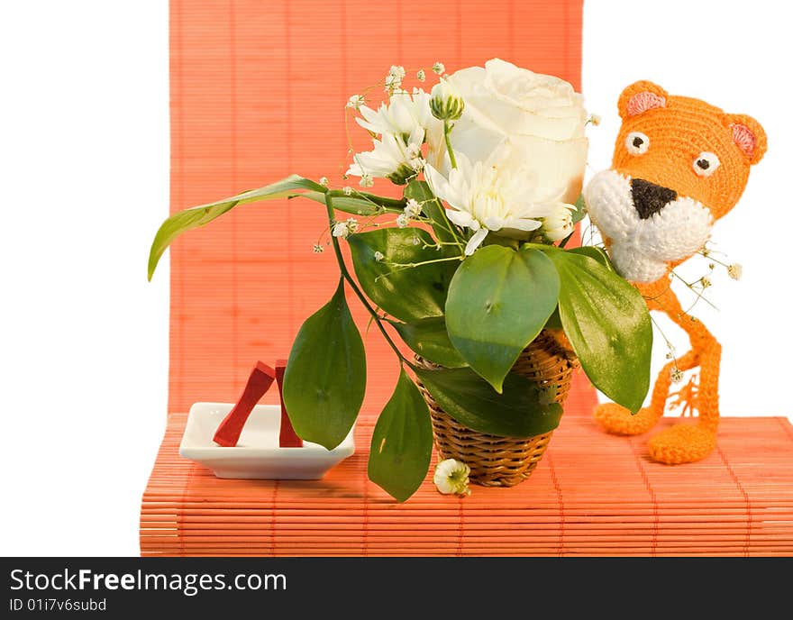 Hand made orange knitted tiger for ornamental pattern and vase with white rose