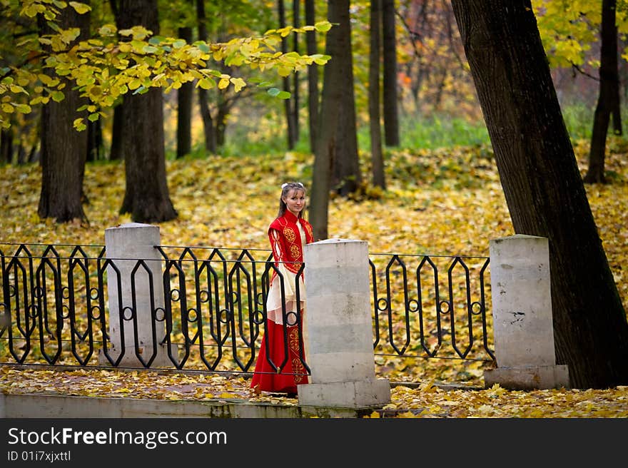 Lady in medieval red dress in the autumn forest. Lady in medieval red dress in the autumn forest