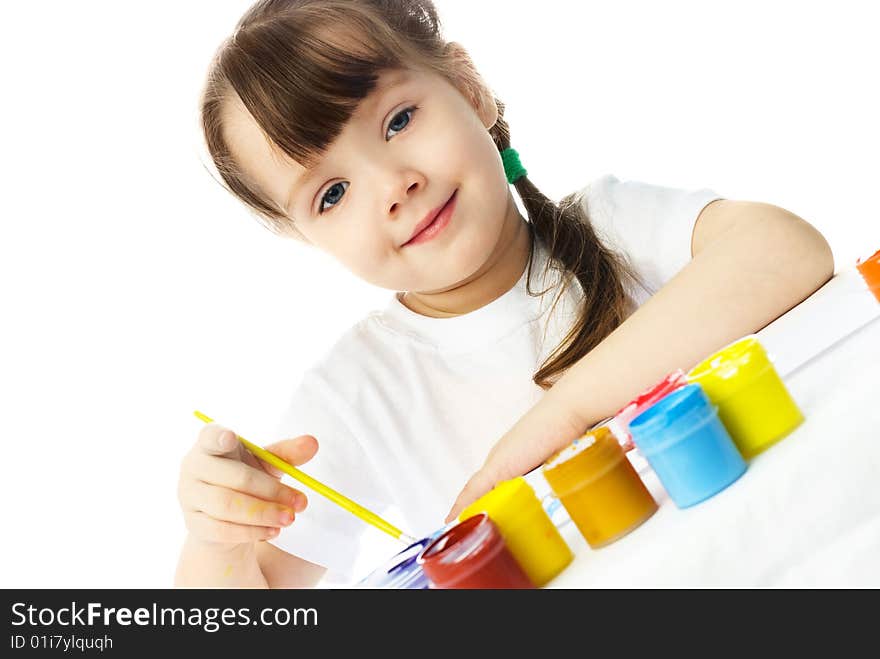 Cute little girl sitting by the table and painting with watercolor. Cute little girl sitting by the table and painting with watercolor