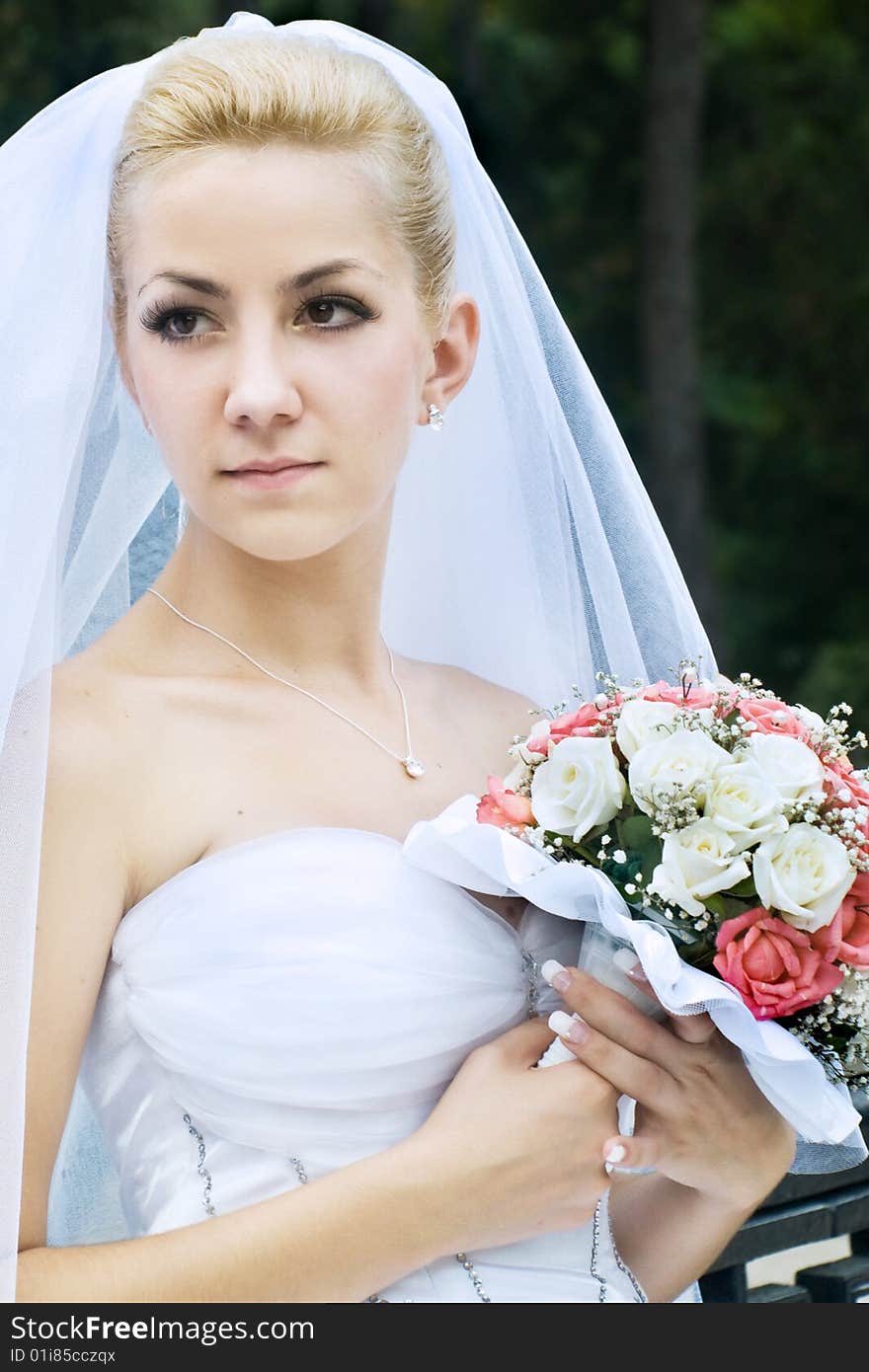 Portrait of beautiful bride with bouquet outdoor shot