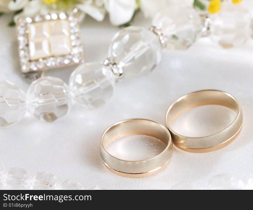 Closeup of wedding rings and beads