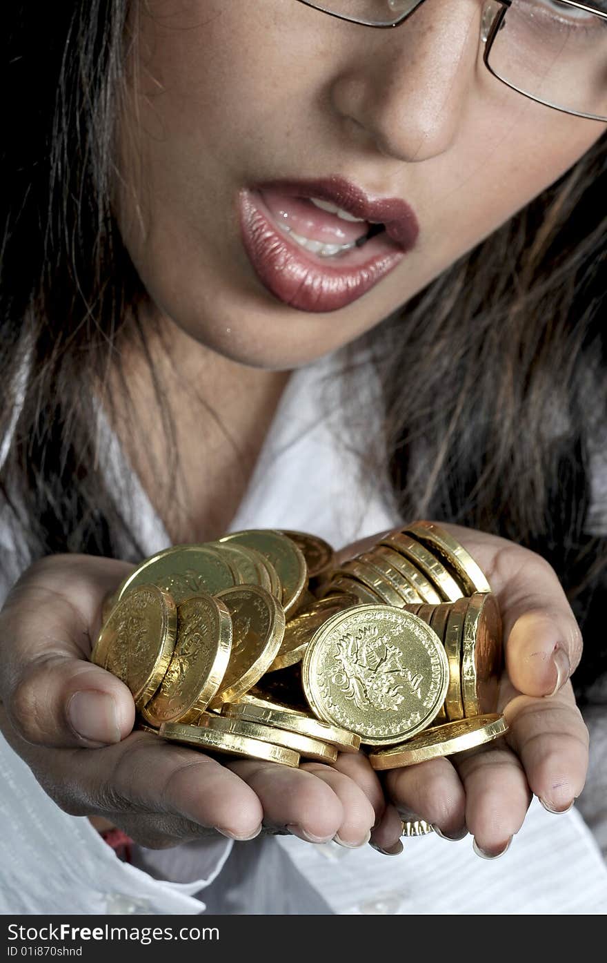 Girl with golden coins in studio.