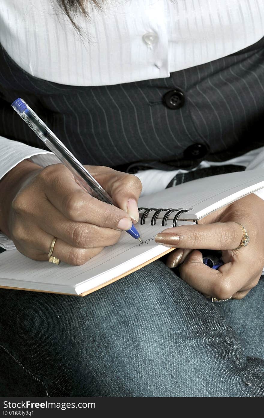 Girl writing on the pad.