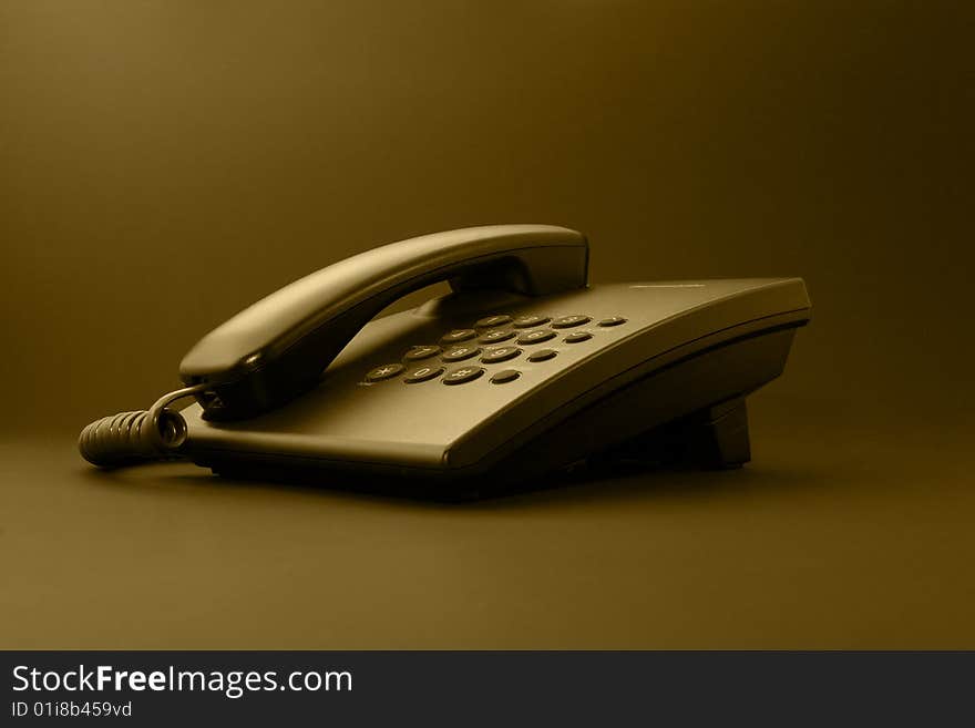 Black office phone with cord isolated on black under sepia. Black office phone with cord isolated on black under sepia