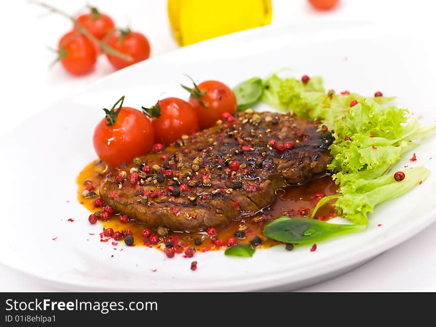 A grilled peppercorn - steak with tomato lettuce