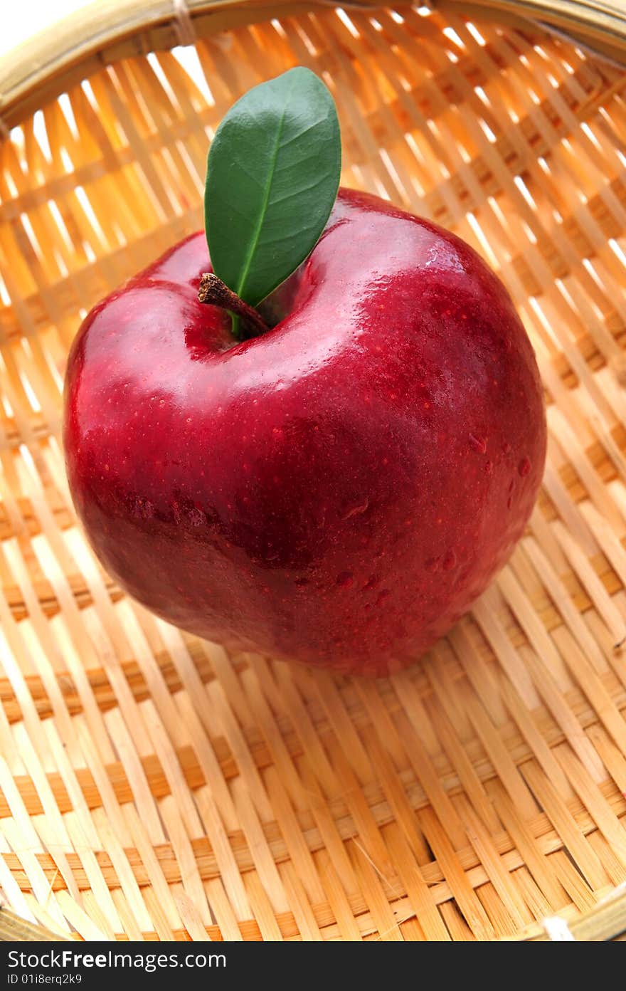 Red apple with leaf in basket