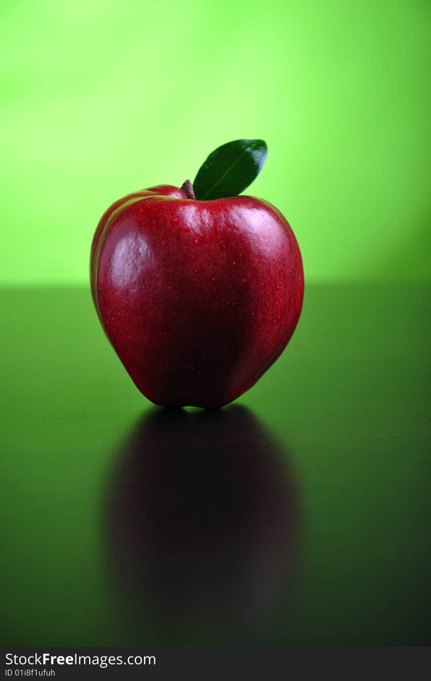 Red apple with leaf on a table