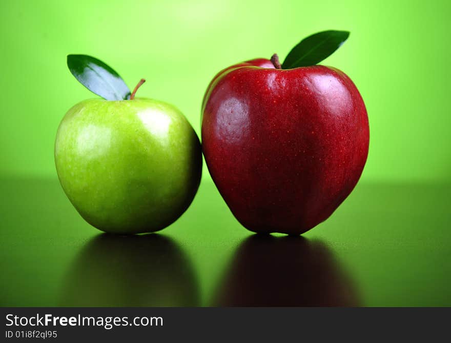 A green and a red apple on a table. A green and a red apple on a table