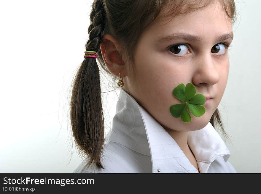 Little girl holding a clover in corner of her mouth. Little girl holding a clover in corner of her mouth