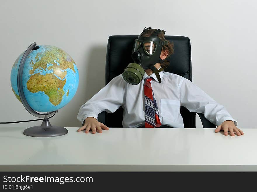 Businessman with gas mask on face looking at earth globe. Businessman with gas mask on face looking at earth globe