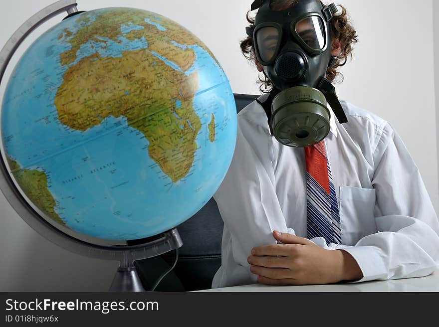 Businessman with gas mask on face looking at earth globe. Businessman with gas mask on face looking at earth globe