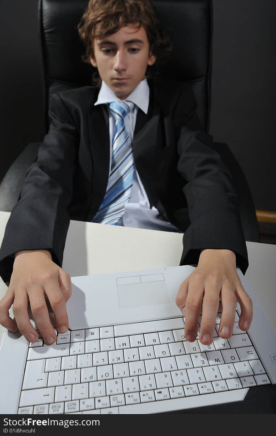 Young businessman at desk using computer laptop. Young businessman at desk using computer laptop