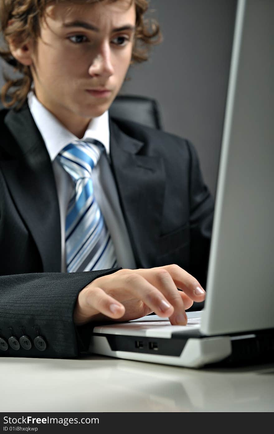 Young businessman at desk using computer laptop. Young businessman at desk using computer laptop