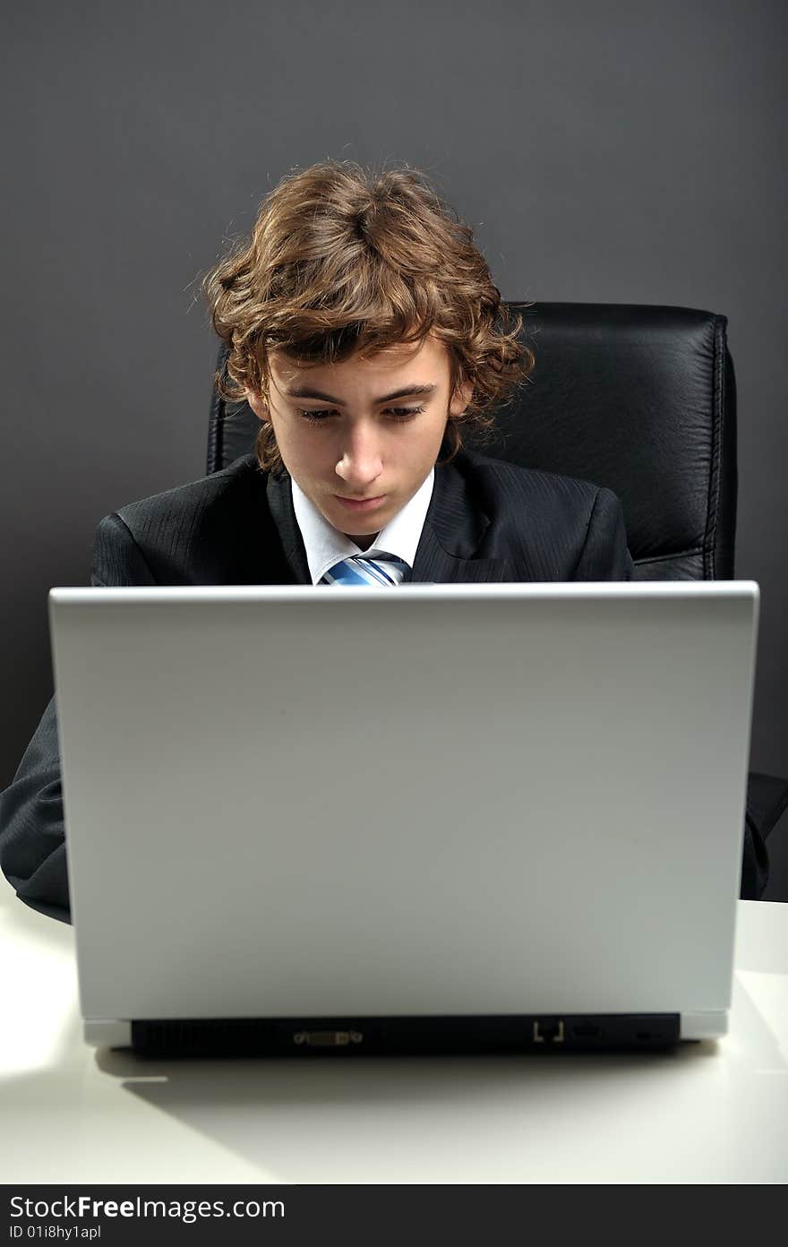 Young businessman at desk using computer laptop. Young businessman at desk using computer laptop