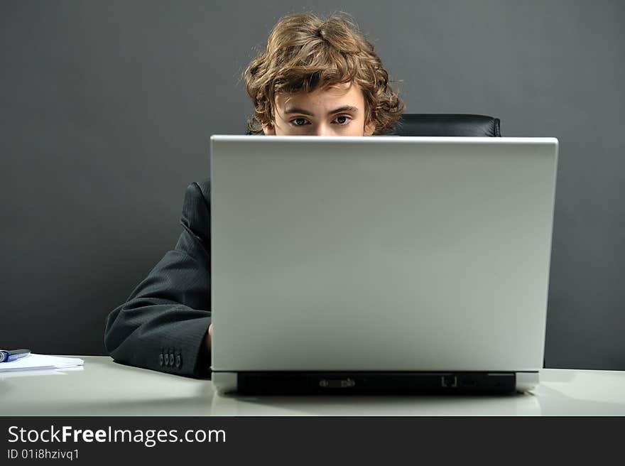 Young businessman at desk using computer laptop. Young businessman at desk using computer laptop