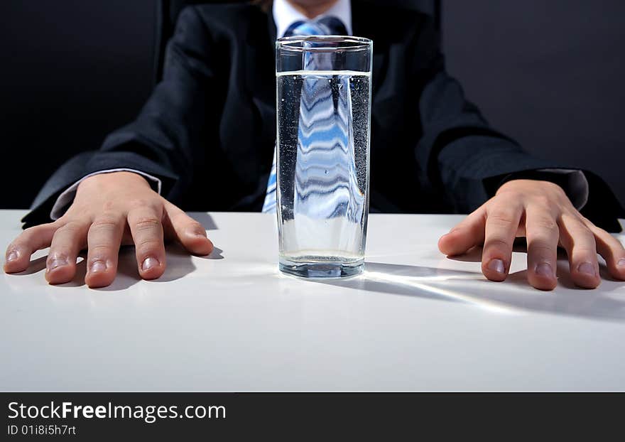 Businessman hands and glass of water on desk. Businessman hands and glass of water on desk