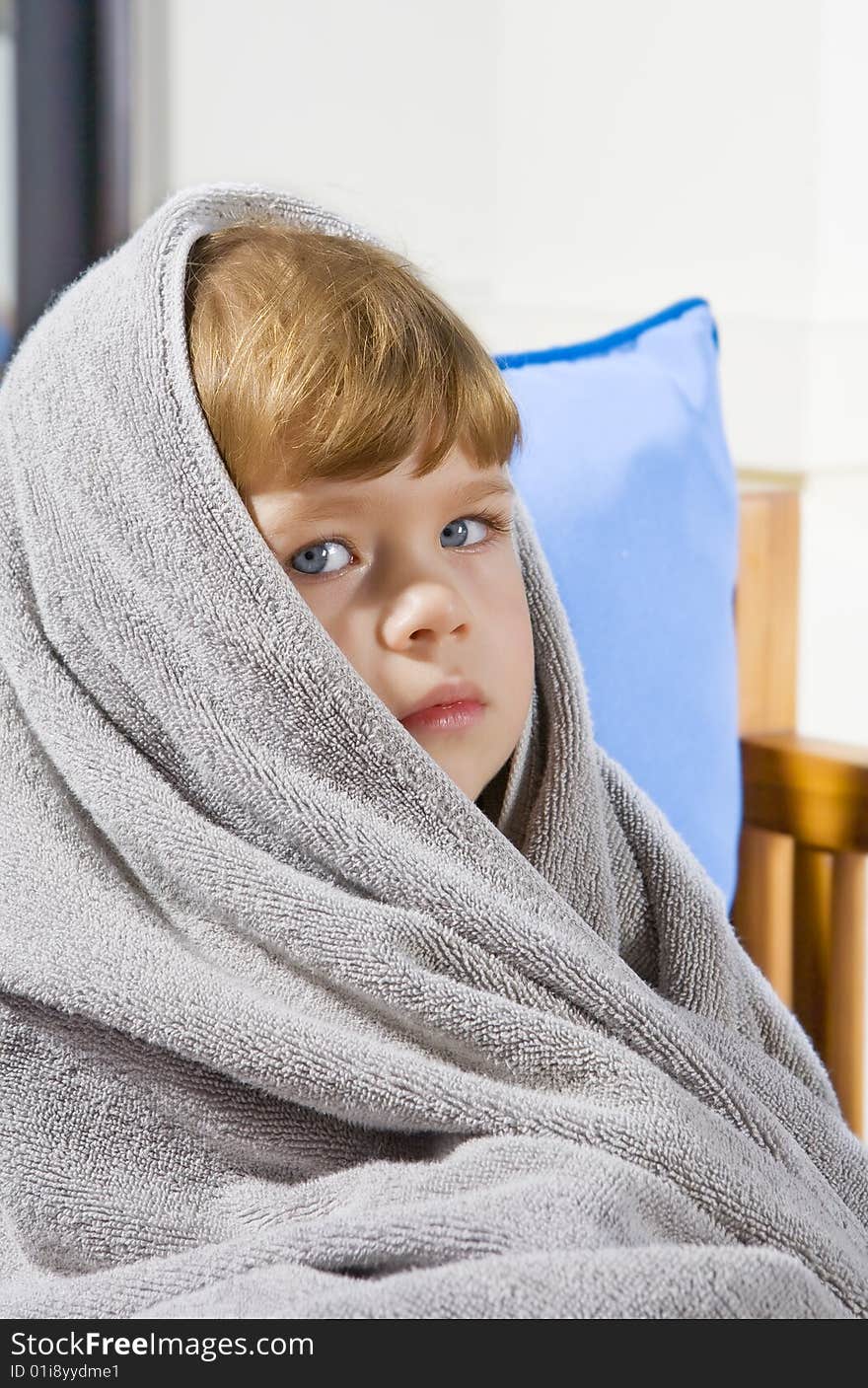 Portrait of beautiful little blue eyed  girl wrapped in towel