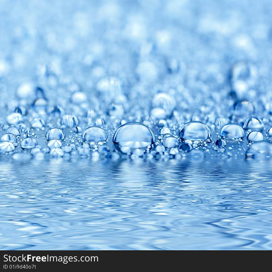 Blue droplets reflected in the water