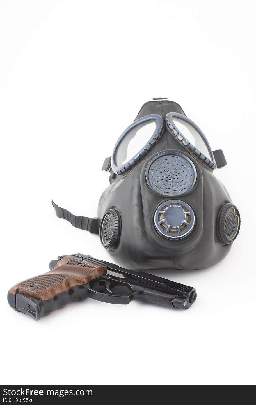 Pistol and gas mask over white background