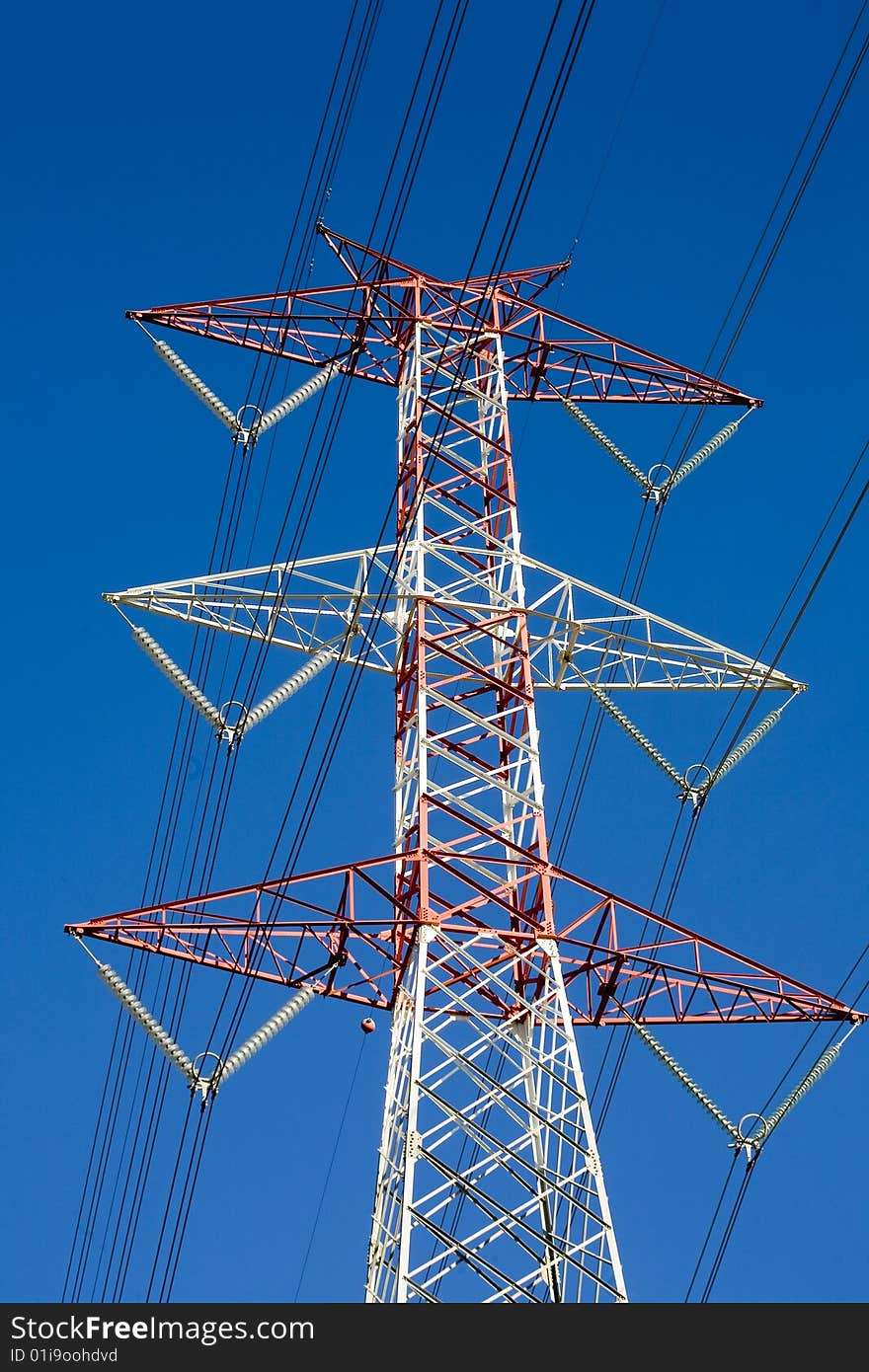 View from the bottom of a high voltage pylon in the background with the sky blue. View from the bottom of a high voltage pylon in the background with the sky blue