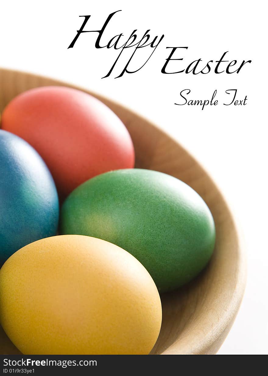 Colorful easter eggs in wooden bowl. Space for your text.