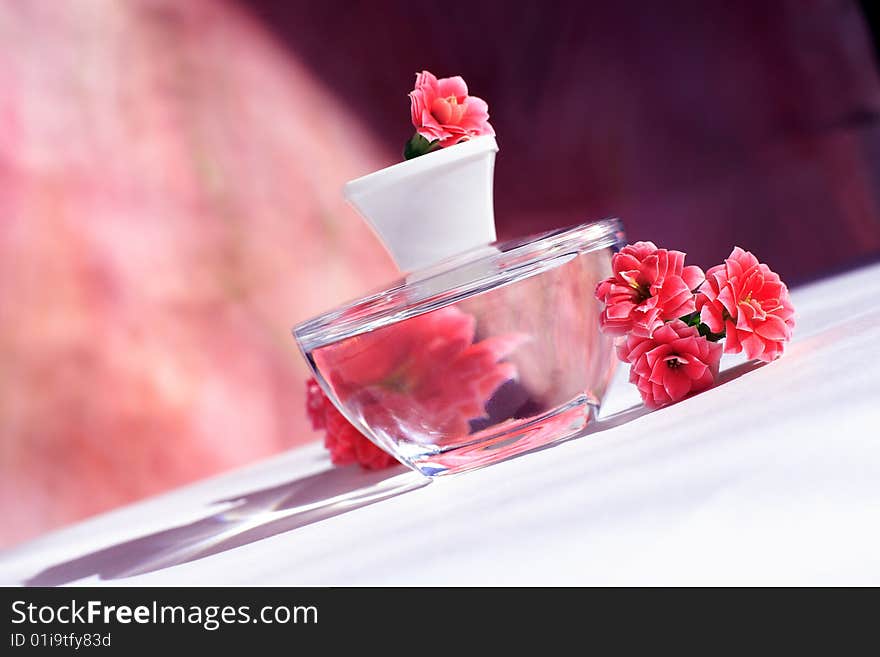 Perfume bottle with red flowers with reflection. Perfume bottle with red flowers with reflection