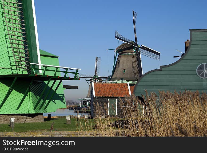 Typical view in the Zaansche Schans in the Netherlands where you can find a collection of old Dutch Wind mills. This windmill named
 “De Kat”  is Paint Mill, for grinding pigments for the manufacturing of paint and the green colored Wood Sawing Mill Paltrok or post mill named 'De Gekroonde Poelenburg' (detail) , Zaanse homes, decorated with typical Zaans green colored paint. Typical view in the Zaansche Schans in the Netherlands where you can find a collection of old Dutch Wind mills. This windmill named
 “De Kat”  is Paint Mill, for grinding pigments for the manufacturing of paint and the green colored Wood Sawing Mill Paltrok or post mill named 'De Gekroonde Poelenburg' (detail) , Zaanse homes, decorated with typical Zaans green colored paint.