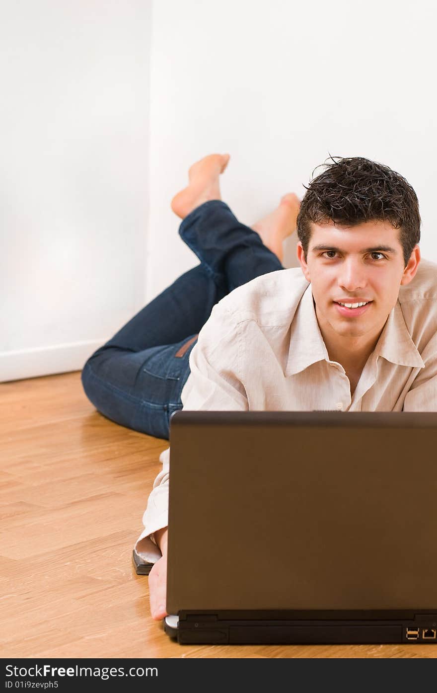 Happy young man working on his laptop with casual clothing. Happy young man working on his laptop with casual clothing