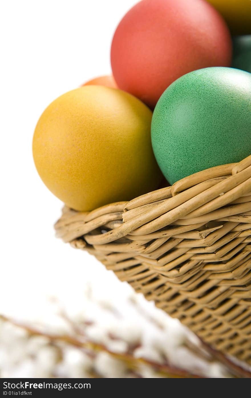 Colorful easter eggs in basket. Some catkins in background. Colorful easter eggs in basket. Some catkins in background.