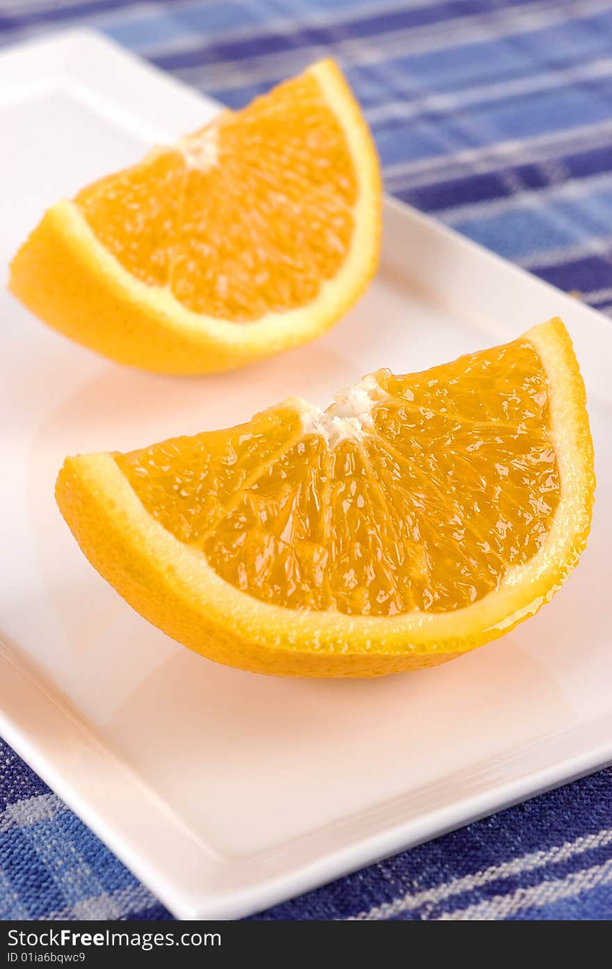 Sliced oranges on a white plate with selective focus