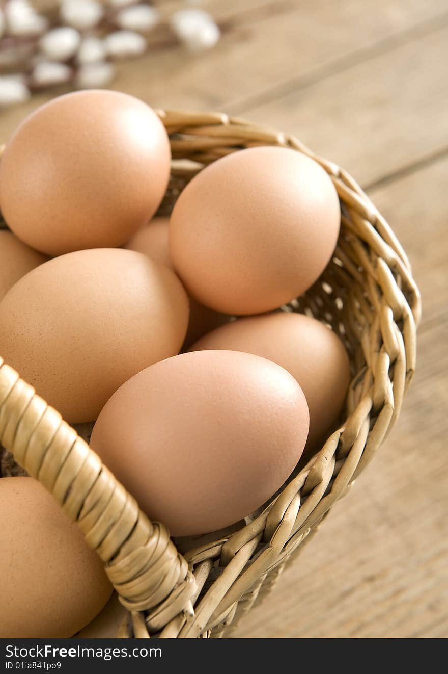 Easter eggs in basket on wooden boards.